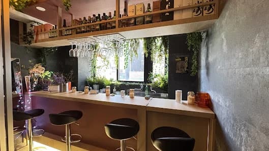 木のカウンターと椅子があるRAKKI GYŌZAの店内
