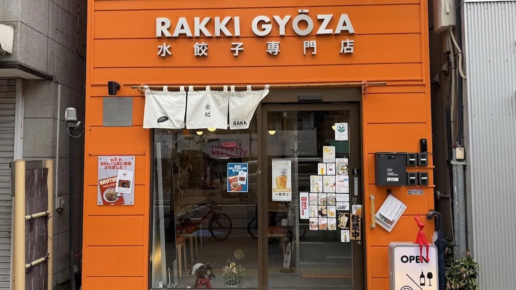 橙色の外壁と白い暖簾が目印の、根津にあるRAKKI GYŌZA楽紀餃子の店舗